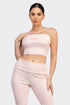 Woman wearing a pink strapless top and pants on a white background