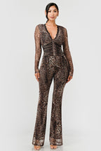 Woman wearing a leopard print jumpsuit on a neutral background