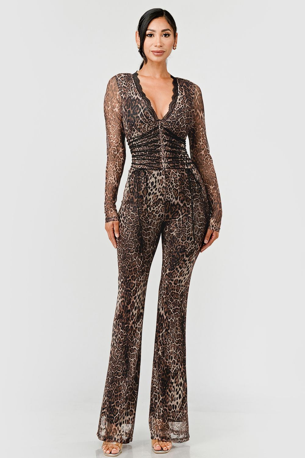 Woman wearing a leopard print jumpsuit on a neutral background