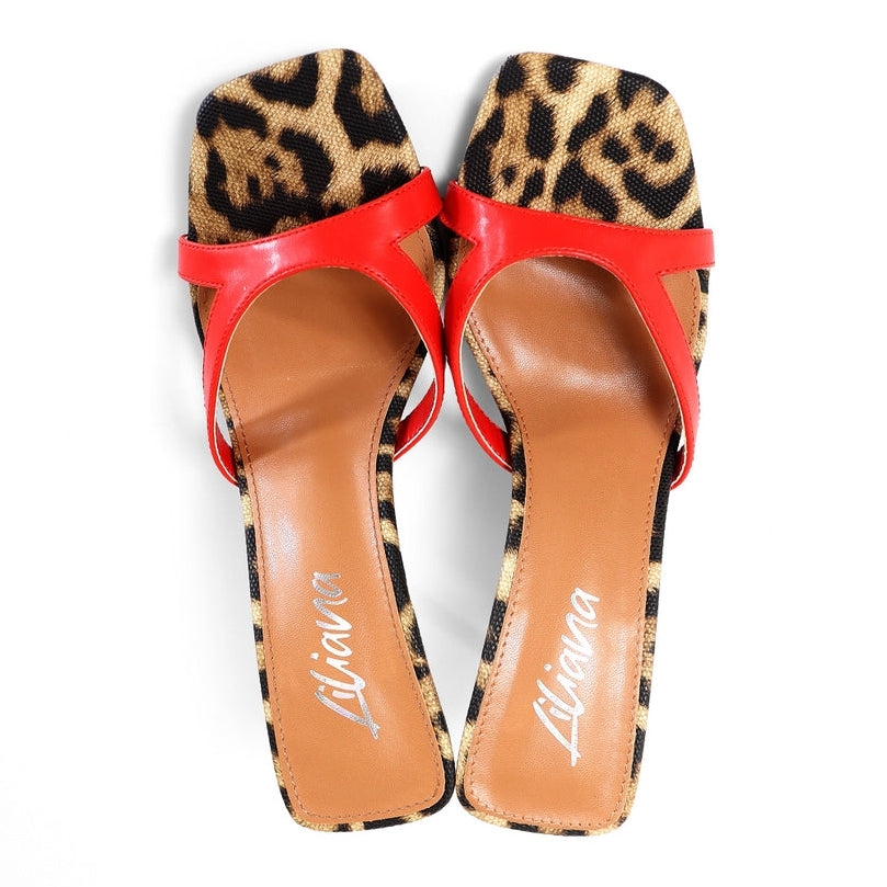 Leopard print high heels with red straps on a white background