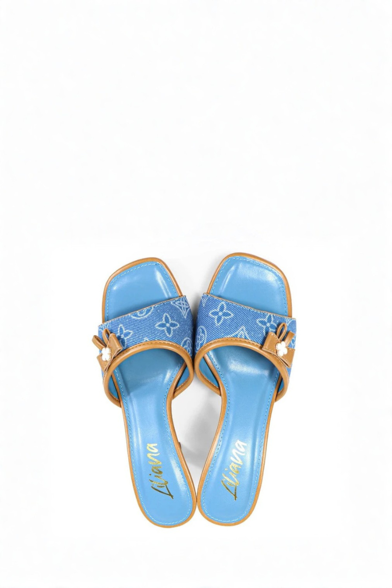 Blue high-heeled shoe with brown bow on a white background