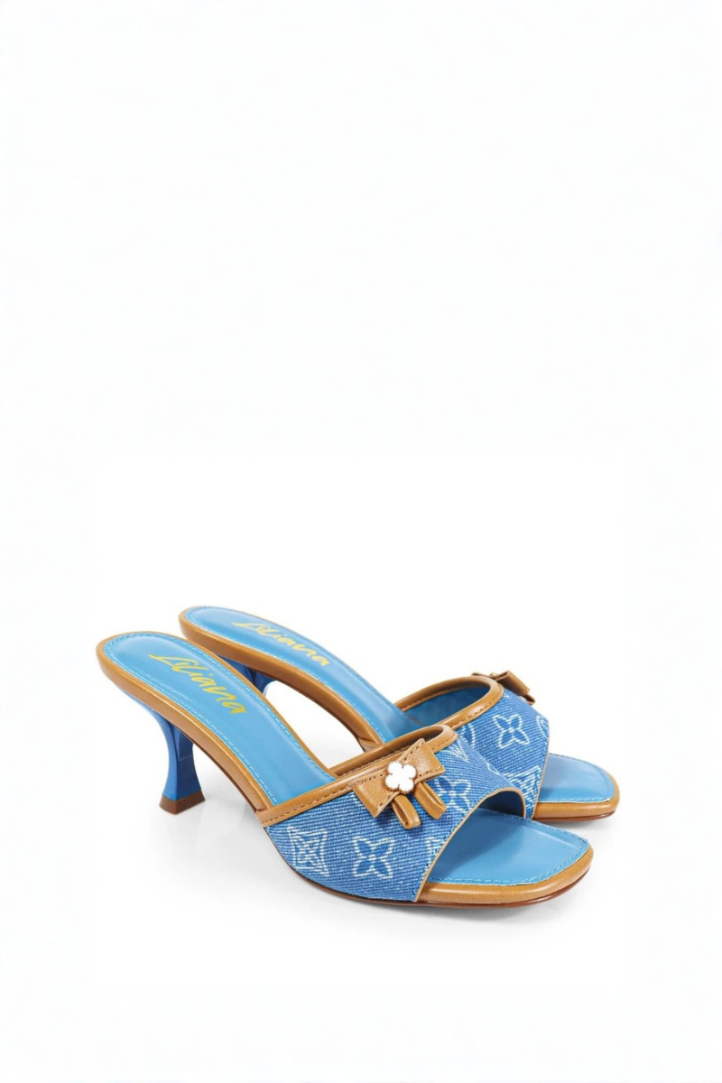 Blue high-heeled shoe with brown bow on a white background
