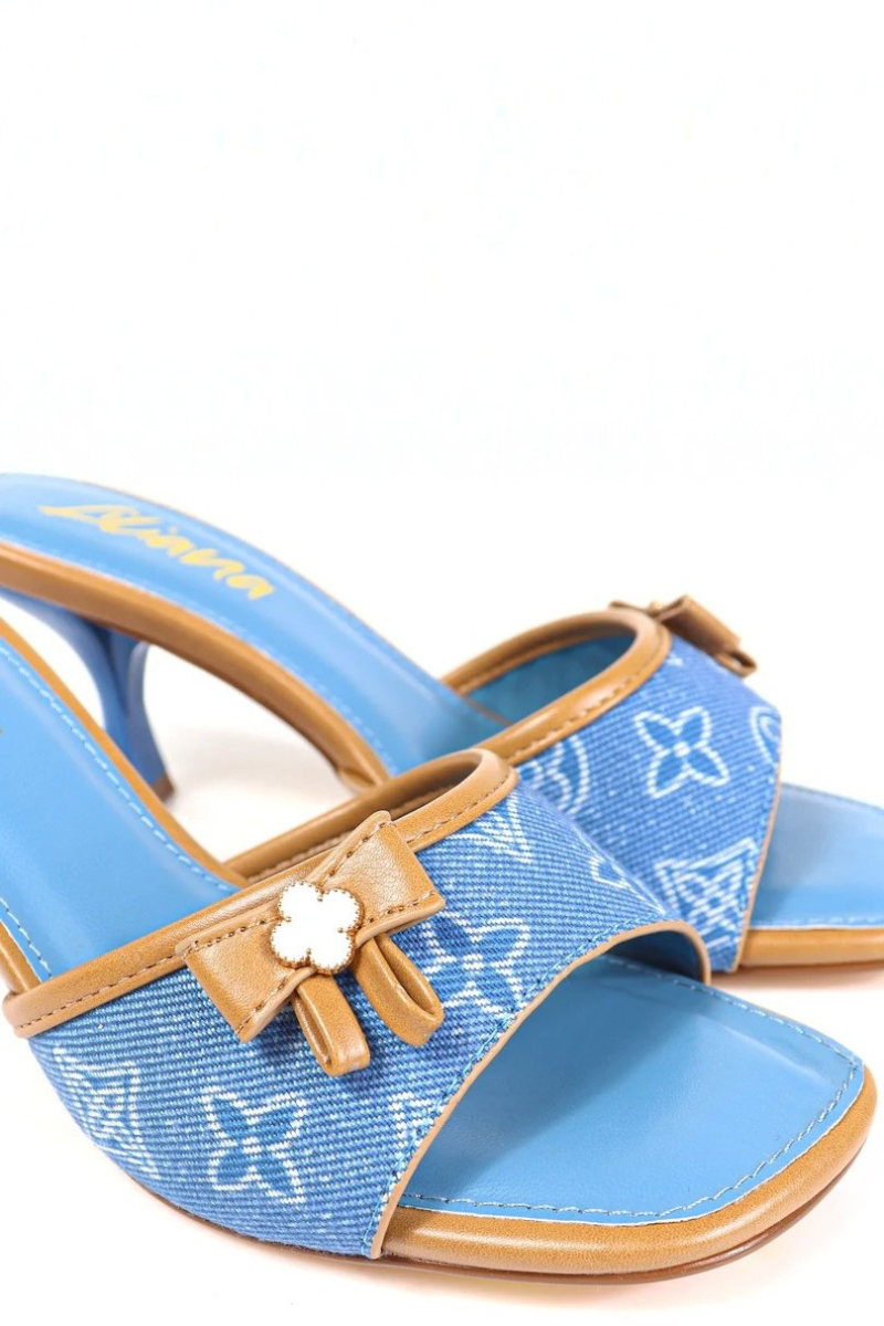 Blue high-heeled shoe with brown bow on a white background